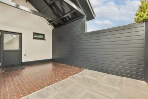 Terrasse avec clôture rigide occultante gris anthracite à lames horizontale