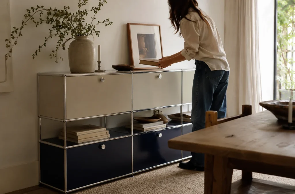 Personne disposant des livres sur un meuble modulaire entouré de bois et de textiles