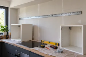 Rail de fixation métallique pour meubles hauts de cuisine posé sur un mur en placo